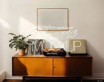 Op de afbeelding: Een houten mid-century modern kast met een platenspeler, vinylplaten en een ingelijst beeld bovenop. De kast heeft twee deuren en is lichtbruin.