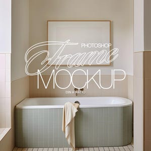 May include: A bathroom scene featuring a rectangular bathtub with a light green tile exterior. A beige towel hangs over the tub's edge. Above, a framed artwork hangs on the wall. The text "Photoshop Frame Mockup" is displayed.