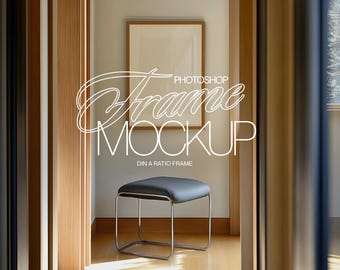 May include: A room interior featuring a framed artwork and a small stool. The artwork is in a light brown frame, and the stool has a black seat and a chrome frame. The text "Photoshop Frame Mockup" is overlaid on the image.
