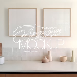 Op de afbeelding: Twee vierkante houten fotolijsten met witte passe-partouts, hangend aan een witte betegelde muur boven een aanrecht met een houten snijplank, een witte keramische kom en verschillende decoratieve vazen. De lijsten zijn leeg en klaar voor uw foto's of kunstwerken.  Photoshop Frame Mockup 1x1 Ratio Frames.