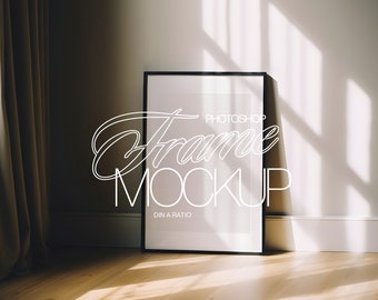 May include: A black picture frame mockup with the text "Photoshop Frame Mockup DIN A Ratio" on a white wall with a brown curtain in the background.
