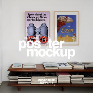 May include: Two framed posters hang on a white wall. One features binoculars and text: "A new view of the new you. Widen your food choices." The other depicts a camel and the word "Egypt." A wooden shelf below holds books.