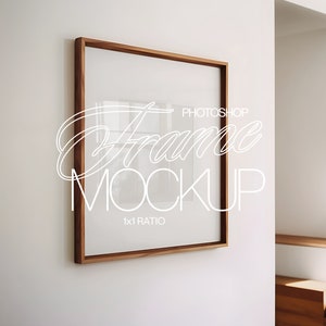 May include: A brown wood frame with a white mount and a white background. The frame is hanging on a white wall. The text "Photoshop Frame Mockup 1x1 Ratio" is written in white on the frame.