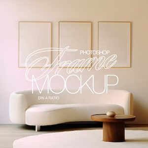 Peut inclure: Trois cadres photo dorés accrochés à un mur beige au-dessus d'un canapé blanc incurvé et d'une table basse en bois. Le texte "Frame Mockup" est écrit en blanc sur le mur.