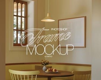 May include: A white frame mockup with the text "PHOTOSHOP Frame MOCKUP 1x1 RATIO" in a light gray font. The frame is hanging on a beige wall above a wooden table with a yellow cushioned bench and a chair. There are apples and flowers on the table.