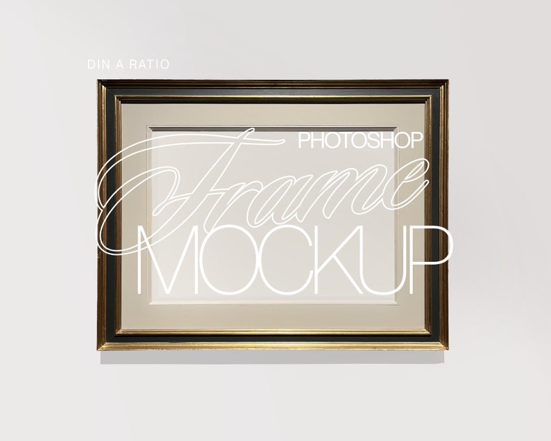 May include: A gold-toned picture frame with a black inner border. The frame is hanging on a white wall. The text "PHOTOSHOP Frame MOCKUP" is written in white on the frame.