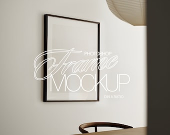 May include: A black frame mockup with a white background. The frame is hanging on a white wall. The text "Frame Mockup" is written in white on the frame. The text "Photoshop" is written in white above the text "Frame Mockup". The text "DIN A Ratio" is written in white below the text "Frame Mockup".