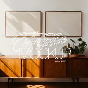 Puede incluir: Dos maquetas de marcos rectangulares de madera cuelgan sobre un mueble de madera de estilo moderno de mediados de siglo. El mueble tiene dos juegos de puertas y una planta encima. El texto "Photoshop Frame Mockup" está escrito en cursiva.