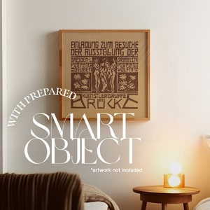 May include: A framed print of a vintage poster with the text "EINLADUNG ZUM BESUCHE DER AUSSTELLUNG DER" and "KUENSTLERGRUPPE BR"C"KE". The poster is in a brown wood frame and is hanging on a white wall. The text "WITH PREPARED SMART OBJECT *artwork not included*" is written in white text below the frame.