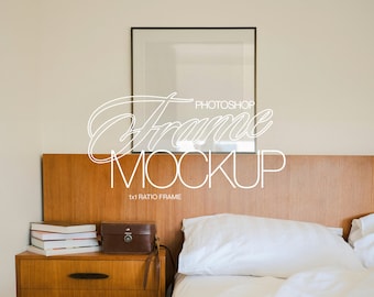 May include: A white bed with a wooden headboard and a framed picture above it. There is a nightstand with a book stack and a small box on it.