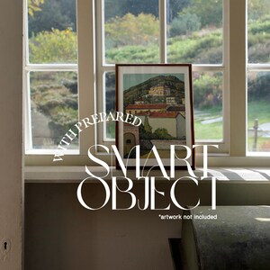 K&ouml;nnte beinhalten: Ein gerahmtes Bild einer Landschaft mit einem Dorf in der Ferne. Der Rahmen ist aus braunem Holz und das Bild befindet sich auf einer wei&szlig;en Fensterbank. Der Text "SMART OBJECT" steht in wei&szlig;en Buchstaben auf einem wei&szlig;en Kreis mit dem Text "WITH PREPARED" in einem Halbkreis dar&uuml;ber. Der Text "*artwork not included" befindet sich unter dem Kreis.