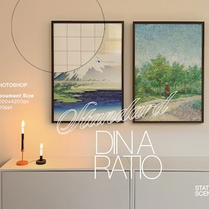 May include: Two framed paintings hanging on a light beige wall above a white dresser. The painting on the left depicts a mountain scene with a blue lake and a white mountain peak. The painting on the right depicts a green forest scene with a single figure walking on a path. The text "Standard DIN A Ratio" is written in white cursive letters on the wall below the paintings.