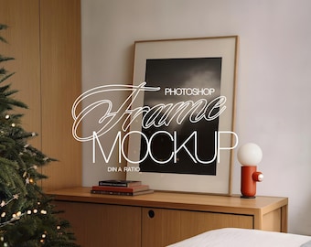 May include: A framed photo mockup with a black and white image inside. The frame is on a wooden dresser with a lamp and books on the surface. The text "Photoshop Frame Mockup" is written in white on the image.