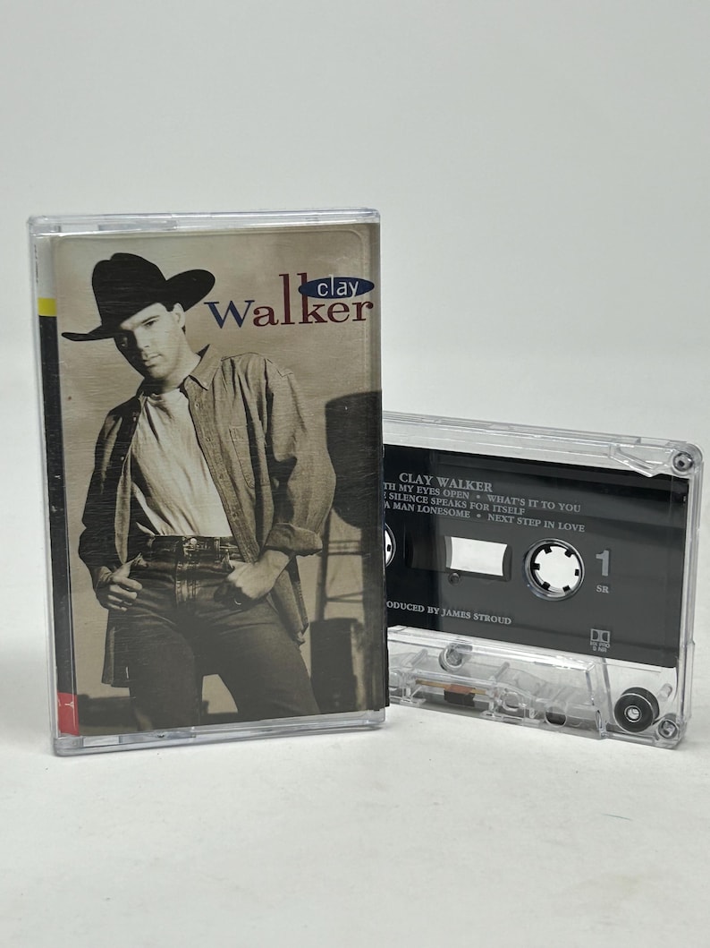 May include: A vintage cassette tape featuring Clay Walker's album cover. The cover shows a black and white image of a man wearing a hat and a button-down shirt. The cassette is in a clear plastic case.