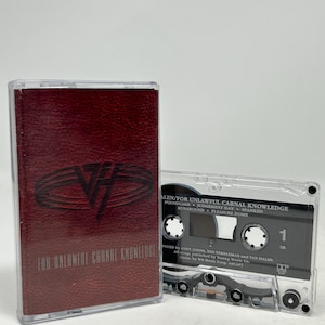 Op de afbeelding: Een cassettebandje met een bordeauxrode hoes met de tekst "FOR UNLAWFUL CARNAL KNOWLEDGE" en een logo. Het doorzichtige cassettebandje ernaast toont de tracklist en de productiecredits. De albumtitel is ook zichtbaar op de cassette.