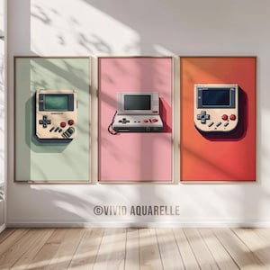 May include: Three framed prints of retro video game consoles on a white wall. The prints are on a light green, pink, and orange background. The consoles are a Game Boy, a Game & Watch, and a Nintendo Entertainment System.