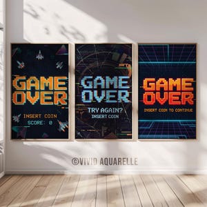 Pode incluir: Três cartazes emoldurados com tema de videojogos retro. Cada cartaz apresenta "GAME OVER" em uma fonte pixelizada. Um diz "INSERT COIN SCORE: 0", outro diz "TRY AGAIN? INSERT COIN", e o último diz "INSERT COIN TO CONTINUE". O fundo é escuro com gráficos pixelizados.