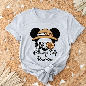 May include: Gray t-shirt with a cartoon image of Mickey Mouse wearing a safari hat, sunglasses, and the text "Disney Trip Paw Paw".