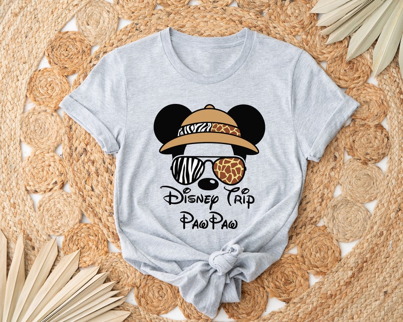 May include: Gray t-shirt with a cartoon image of Mickey Mouse wearing a safari hat, sunglasses, and the text "Disney Trip Paw Paw".