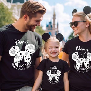 Puede incluir: Una familia de tres personas con camisetas negras con orejas de Mickey Mouse blancas y un dise&ntilde;o gr&aacute;fico blanco. Las camisetas dicen "Pap&aacute;", "Mam&aacute;" y "Emily" con el texto "Disney Family Vacation 2025" en cada camiseta.