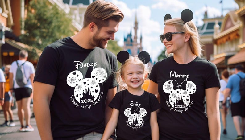 Puede incluir: Una familia de tres personas con camisetas negras con orejas de Mickey Mouse blancas y un dise&ntilde;o gr&aacute;fico blanco. Las camisetas dicen "Pap&aacute;", "Mam&aacute;" y "Emily" con el texto "Disney Family Vacation 2025" en cada camiseta.