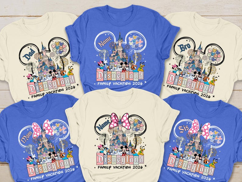 K&ouml;nnte beinhalten: Cremefarbene und blaue T-Shirts mit Rundhalsausschnitt und Disneyland-Design. Das Design zeigt das Disneyland-Schloss, Micky und Minnie Maus und andere Charaktere. Der Text enth&auml;lt "Dad", "Mom", "Bro", "Sis" und "Name" sowie "Family Vacation 2026".
