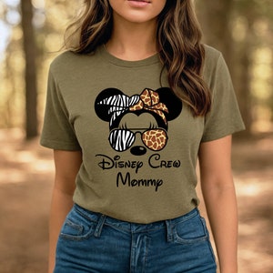 May include: A green t-shirt with a black and white zebra print, brown and tan giraffe print, and black sunglasses on a cartoon mouse head. The text "Disney Crew Mommy" is printed below the mouse head.