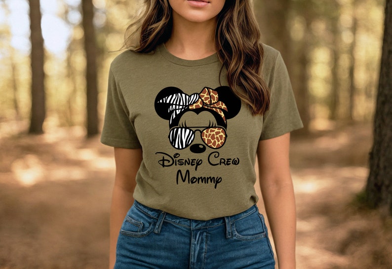 May include: A green t-shirt with a black and white zebra print, brown and tan giraffe print, and black sunglasses on a cartoon mouse head. The text "Disney Crew Mommy" is printed below the mouse head.