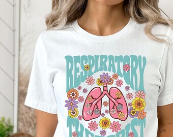 May include: White t-shirt with a teal blue graphic of a pair of pink lungs with flowers around them. The text "Respiratory Therapist" is in a teal blue font.