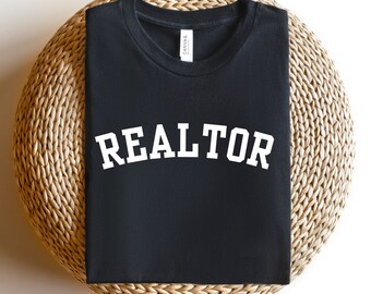 May include: Black t-shirt with the word "REALTOR" printed in white on the front.