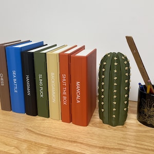 Peut inclure: Une collection de jeux de soci&eacute;t&eacute;, dont &Eacute;checs, Sea Battle, Hangman, Sling Puck, Backgammon, Shut the Box et Mancala. Les jeux sont dans des bo&icirc;tes color&eacute;es. Un porte-crayons en forme de cactus vert et un porte-stylo sur le th&egrave;me des Pirates des Cara&iuml;bes sont &eacute;galement pr&eacute;sents.