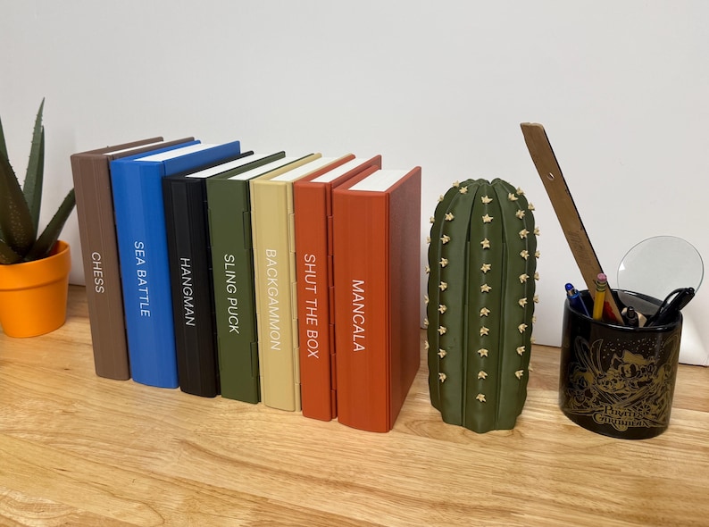 Peut inclure: Une collection de jeux de soci&eacute;t&eacute;, dont &Eacute;checs, Sea Battle, Hangman, Sling Puck, Backgammon, Shut the Box et Mancala. Les jeux sont dans des bo&icirc;tes color&eacute;es. Un porte-crayons en forme de cactus vert et un porte-stylo sur le th&egrave;me des Pirates des Cara&iuml;bes sont &eacute;galement pr&eacute;sents.