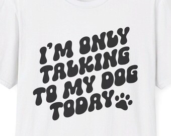 May include: White t-shirt with black text that reads "I'm only talking to my dog today" with a paw print.