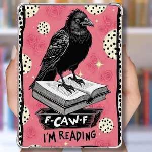 May include: A black and white phone case featuring a black raven perched on an open book. The background is pink with rose and polka dot patterns. The text "F-CAW-F I'M READING" is at the bottom.