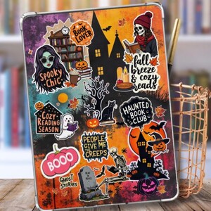 Może przedstawiać: Etui na tablet w tematyce Halloween. Etui posiada naklejki z napisami takimi jak "Spooky Chic", "Cozy Reading Season" i "Haunted Book Club". Inne naklejki to szkielet, dynie, czarny kot i duch. Tło to gradient pomarańczowego, czarnego i fioletowego.