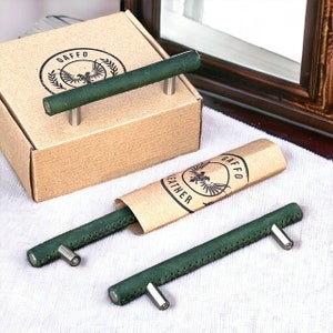 May include: Two green leather drawer pulls with silver hardware. The pulls are packaged in a brown box with the logo "Gaffeo Leather" printed on it.