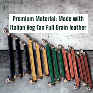 May include: A row of leather drawer pulls in various colours, including black, yellow, green, orange, and brown. The pulls are made of Italian Veg Tan full grain leather and have a brass finish. "Premium Material: Made with Italian Veg Tan Full Grain Leather" is written in white text on a grey background.