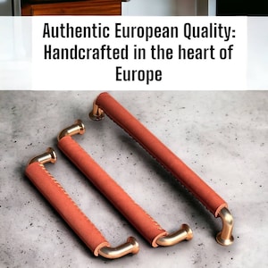 May include: Three leather-wrapped cabinet pulls with a copper finish. The pulls are different sizes and have a stitched design.