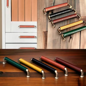 May include: Six leather cabinet pulls in various colors, including green, yellow, black, brown, and red. The pulls have a stitched leather design and a silver metal base.