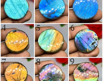 Peut inclure: Neuf cabochons de labradorite ronds présentés en grille. Chaque pierre présente une surface polie avec des reflets irisés distincts, incluant des nuances de bleu vif, jaune doré, violet profond et des motifs arc-en-ciel multicolores.