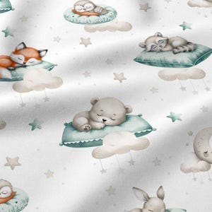 Könnte beinhalten: Weißer Stoff mit einem sich wiederholenden Muster von schlafenden Tieren. Ein Fuchs, ein Waschbär, ein Bär und eine Eule sind auf Kissen und Wolken dargestellt, mit Sternen und Monden im Hintergrund.