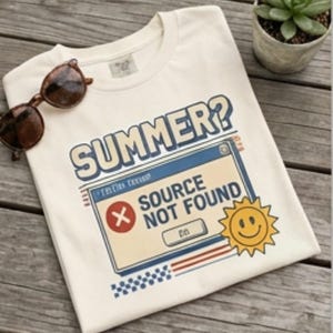 May include: A cream-coloured t-shirt featuring a graphic of a computer error window with the text "SUMMER?" and "SOURCE NOT FOUND" in blue and red, accompanied by a yellow smiley face sun icon and a pair of brown tortoise shell sunglasses.