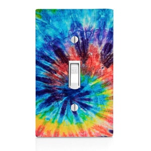 May include: A light switch cover with a colorful tie-dye pattern. The cover features a swirling design in shades of blue, red, yellow, green, and purple.
