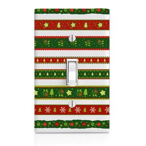 May include: A decorative light switch cover with a festive Christmas design. The cover features alternating horizontal stripes of red, green, and white, adorned with Christmas trees, stars, and snowflakes. The switch itself is white, with the word "OFF" printed on it.
