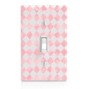 May include: A light switch cover with a pink and white checkered pattern. The cover has a white light switch with the word "OFF" printed on it.