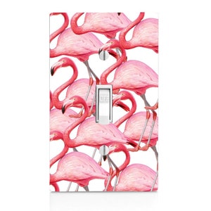 May include: A white light switch cover with a pink flamingo pattern. The switch is labeled "OFF".
