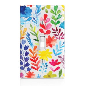 May include: A light switch cover with a colorful floral pattern. The pattern features a variety of flowers and leaves in shades of red, orange, yellow, green, blue, and purple. The switch cover is white and has a standard light switch.