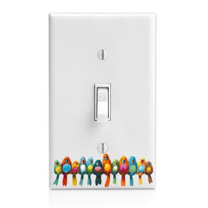 May include: A white light switch cover with a colorful bird decal. The birds are arranged in a row and are painted in various shades of blue, green, yellow, orange, and red.