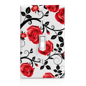 May include: A white light switch cover with a decorative design of red roses and black vines. The switch is labeled "OFF".