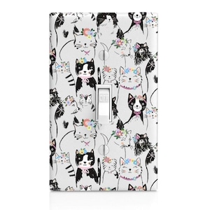 May include: A rectangular light switch cover plate featuring a repeating pattern of black and white cats on a white background. Many cats wear colorful floral crowns and small pink collars. A central white toggle switch is labeled with the word OFF.